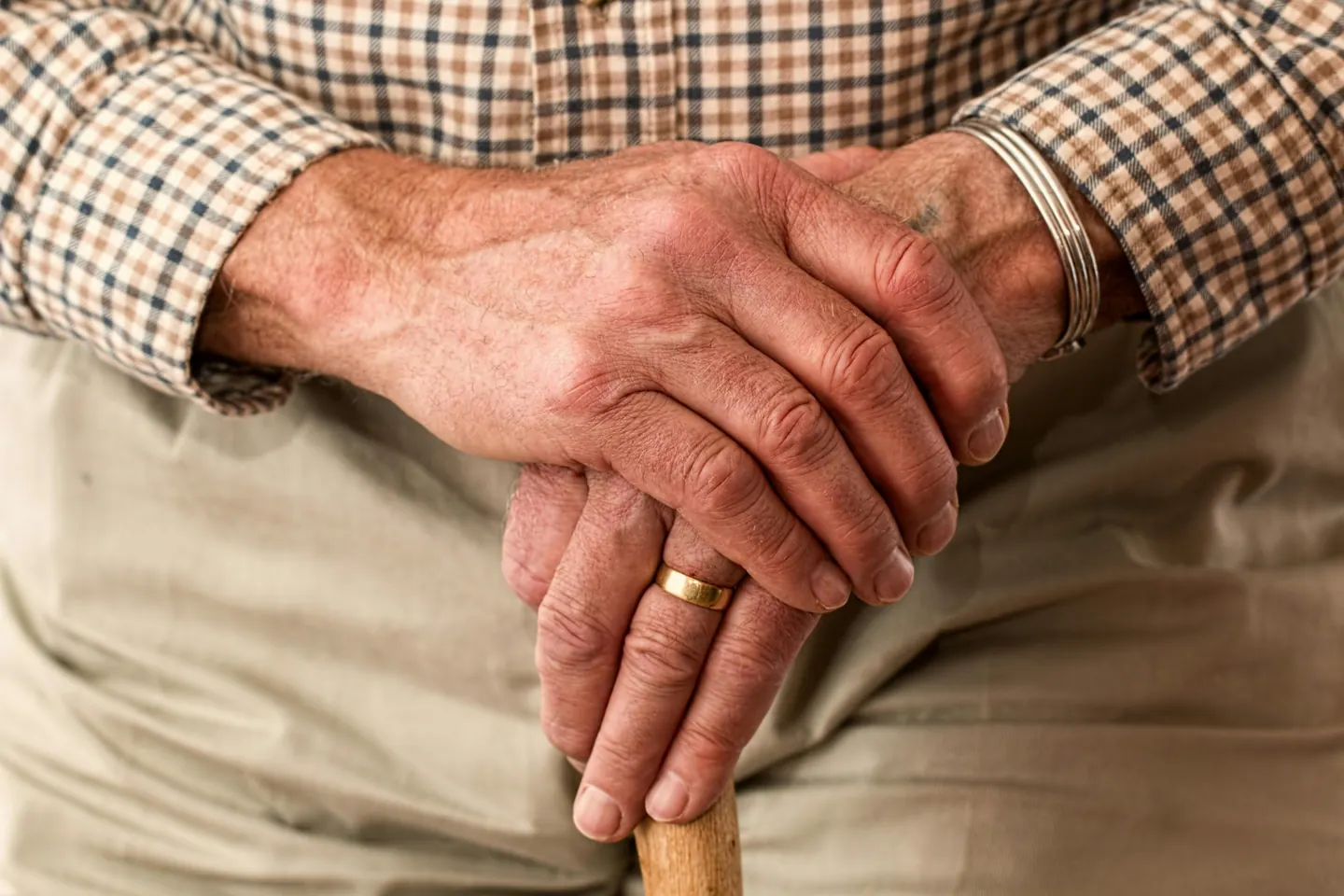 Hands resting on a cane