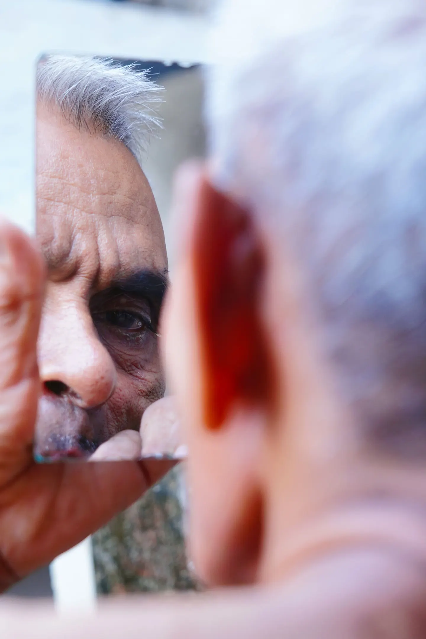 An older man looking into a mirror
