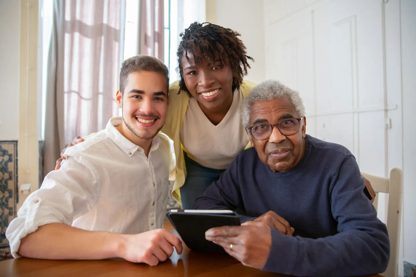 Three adults looking at a tablet together