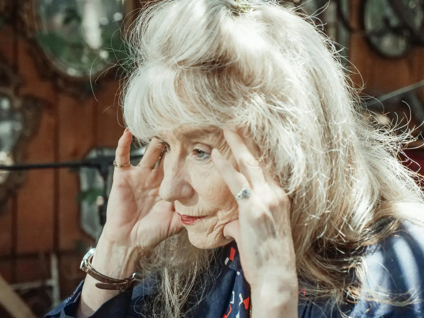 A woman resting a hand on her forehead
